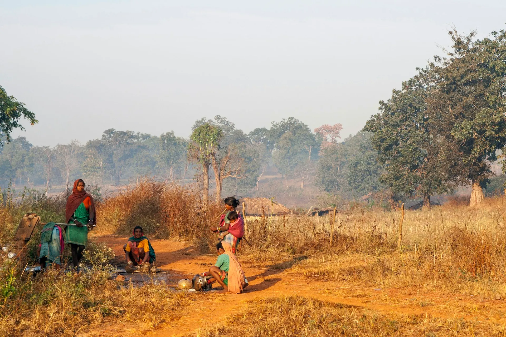 A rural family gathers on a dryland path in Central India at dusk